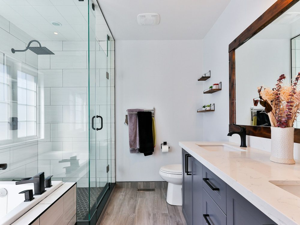 A finished bathroom with glass shower partition